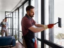 Un aide à domicile nettoyant les vitres (c) freepik