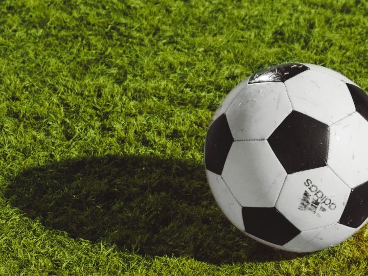 Un ballon de foot posé sur un terrain (c) Wesley Tingey