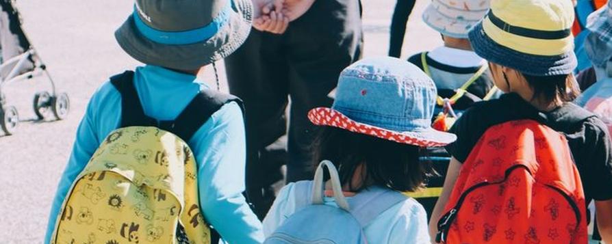 Des enfants de dos avec leur cartable lors d'une sortie (c) note thanun