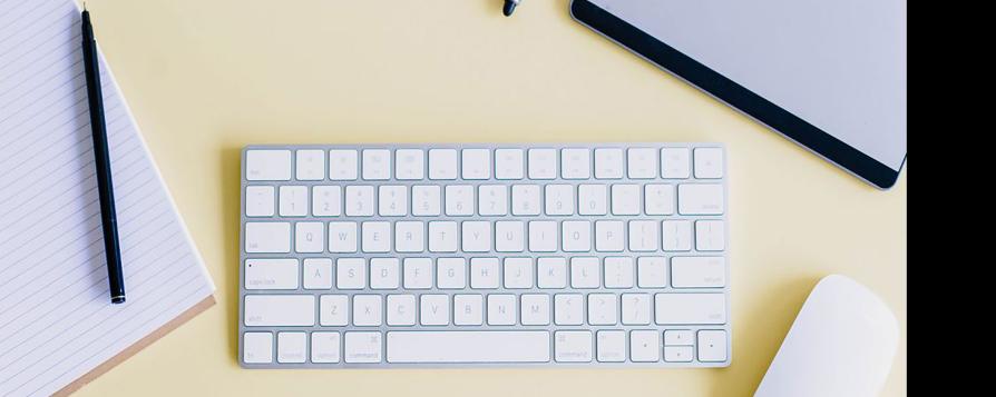 Un clavier d'ordinateur et une souris posés sur un bureau