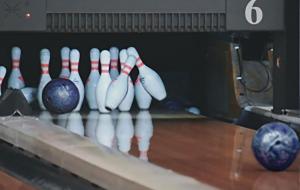 Boule de bowling renversant des quilles