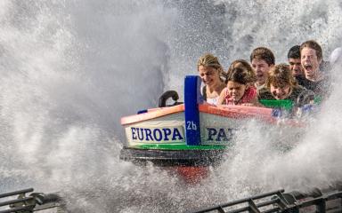 Groupe de personnes dans un manège barque avec gerbe d'eau