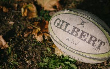 Un ballon de rugby posé sur un terrain (c) M. Cooper
